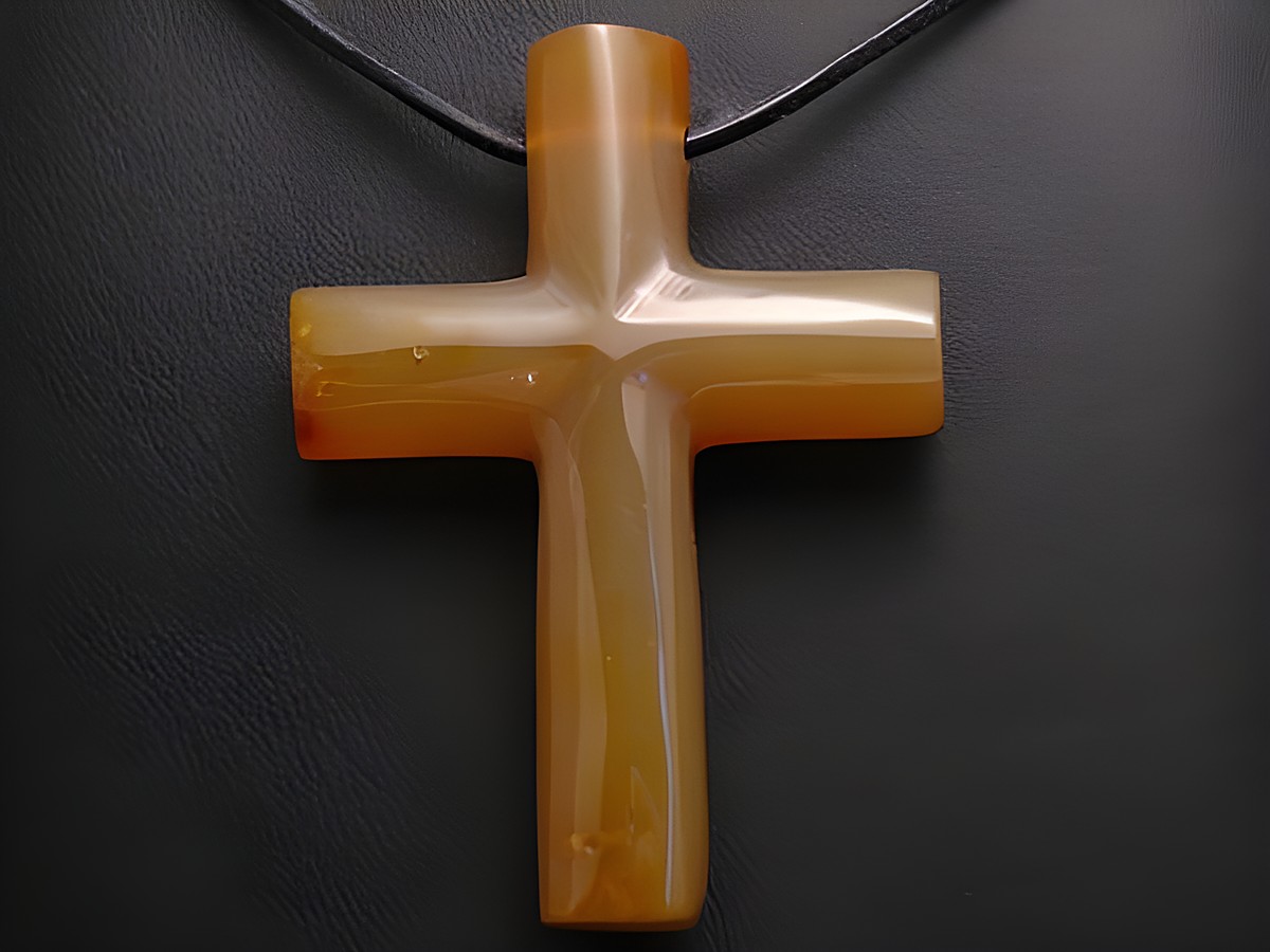 Steinkreuz aus Achat in Bernsteinfarbe mit Lederkette, Hersteller Juwelier Harnisch, Anhänger mit Edelsteinen.