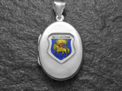 Ein silbernes Medaillon mit dem Stadtwappen von Schwerin, das ein Ritter auf einem Pferd zeigt, umrahmt von blauer und goldener Farbe, hergestellt von Juwelier Harnisch in Mecklenburg-Vorpommern.