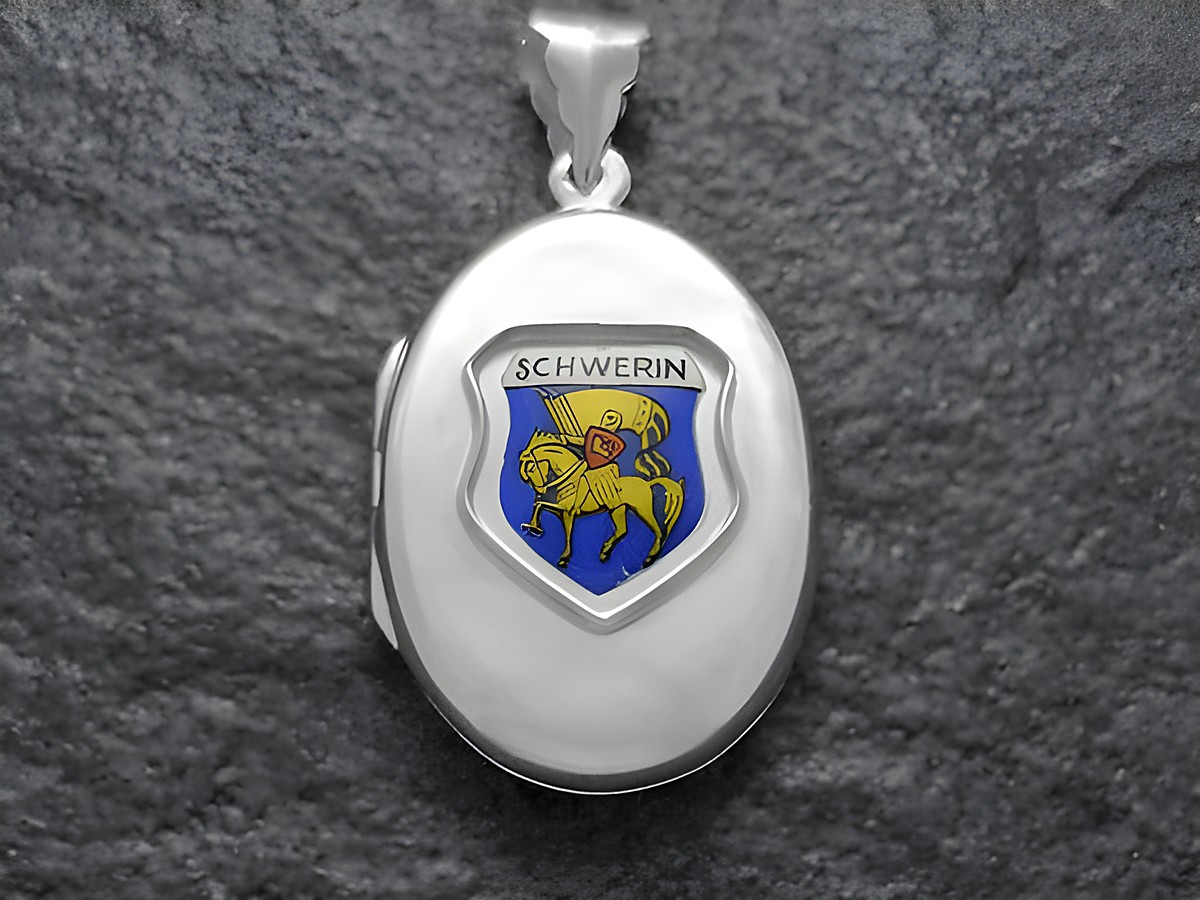 Ein silbernes Medaillon mit dem Stadtwappen von Schwerin, das ein Ritter auf einem Pferd zeigt, umrahmt von blauer und goldener Farbe, hergestellt von Juwelier Harnisch in Mecklenburg-Vorpommern.
