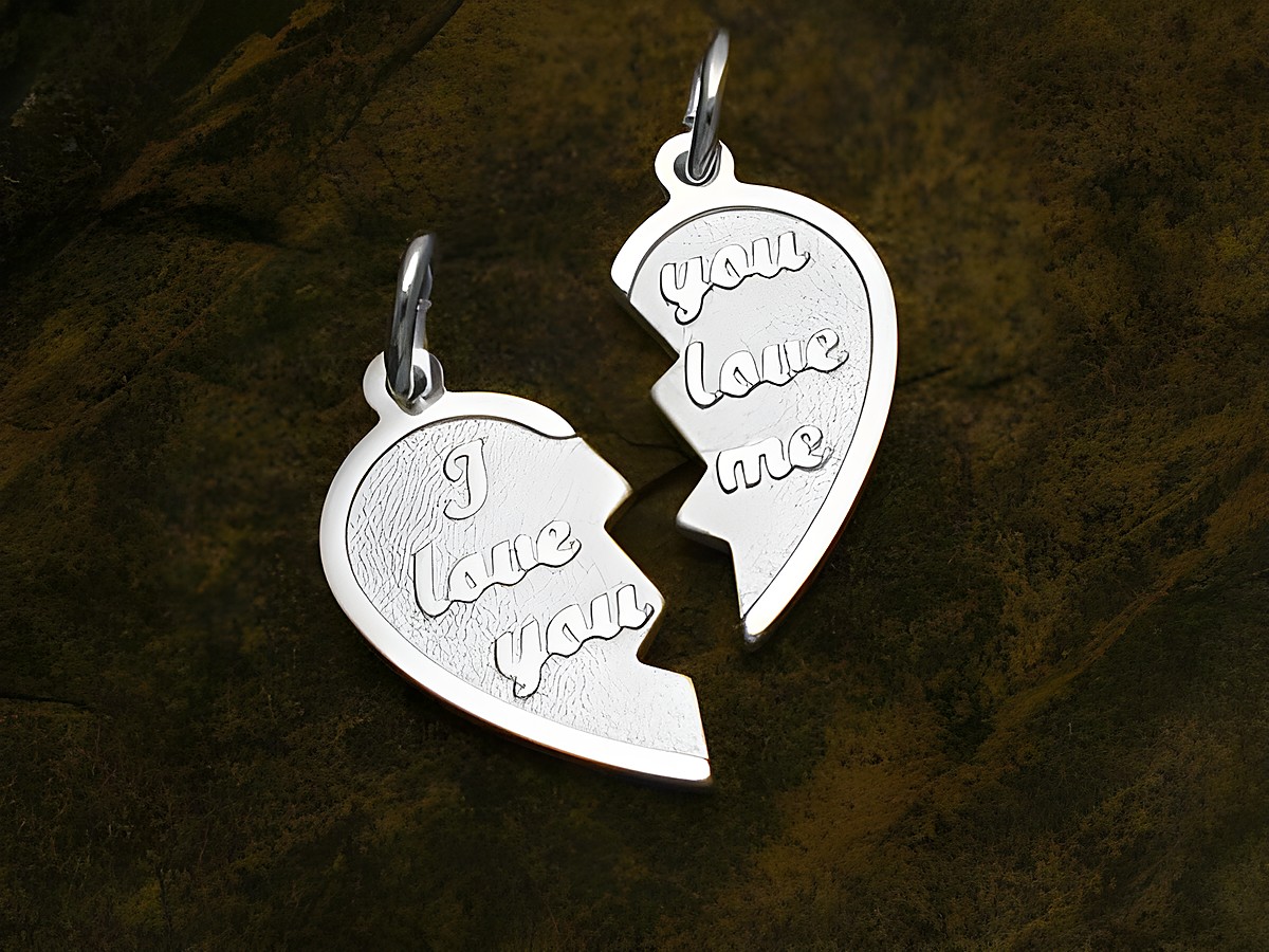 Zwei hängende Partnerherz Anhänger aus Sterling Silber, die in der Mitte geteilt sind und die Inschriften I love you und you love me tragen, ideal als Liebessymbol von Juwelier Harnisch.