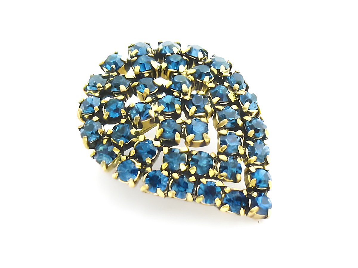 Blaue Strass Brosche im sexy City Look in Form eines Blattes, Hersteller Juwelier Harnisch, verziert mit funkelnden blauen Strasssteinen in goldfarbener Fassung.