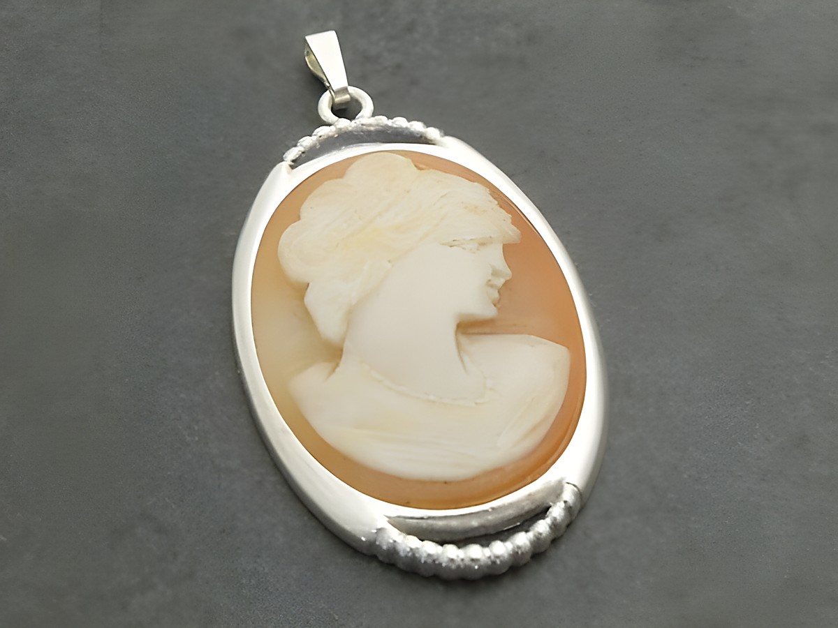 Silber Anhänger mit einer nostalgischen Gemme, die das Profil einer Frau zeigt, kunstvoll eingearbeitet in einen ovalen Rahmen. Hersteller Juwelier Harnisch.