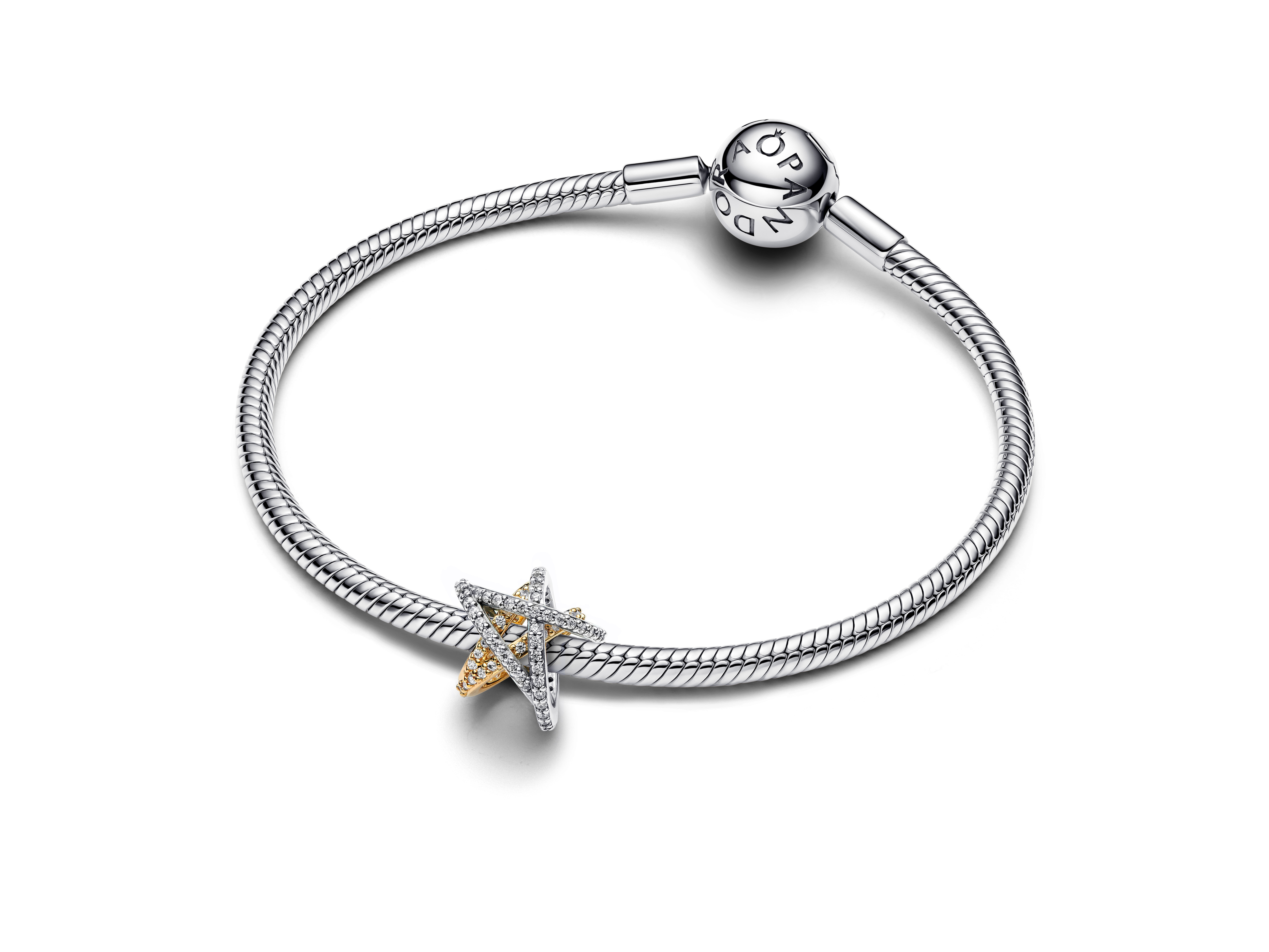 Ein eleganter Pandora Sternanhänger aus Silber und vergoldetem Gelbgold mit klarem Zirkonia, perfekt für moderne Schmuckliebhaber, auf einem geschmeidigen Armband.