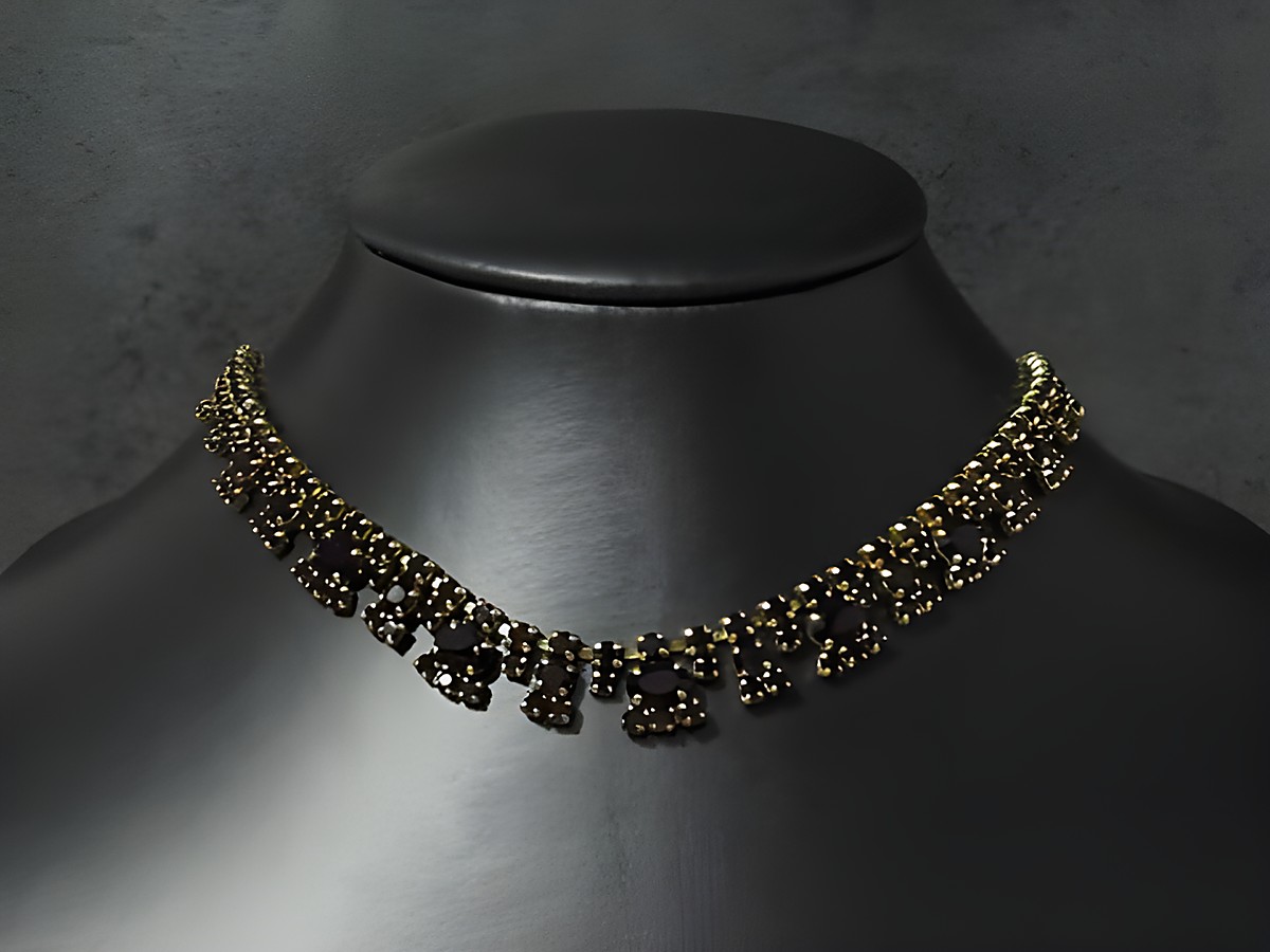 Strass Kette reizend in granatrot von 45 bis 48,5 cm, goldfarbene Fassung, Hersteller Juwelier Harnisch, elegant und funkelnd auf schwarzem Hintergrund präsentiert.