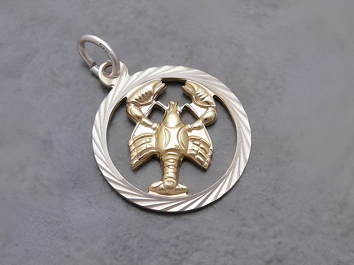 Krebs Silber Sternzeichen mit Vergoldung von Juwelier Harnisch, zeigt ein detailliertes Krebs-Motiv in einem kreisförmigen Rahmen mit gewellter Oberfläche.