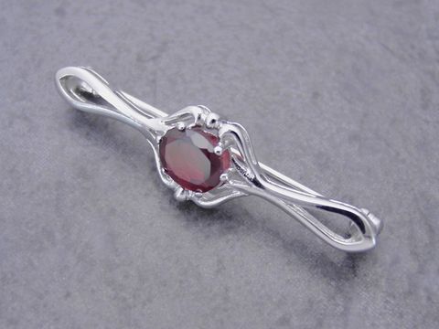 Silber Brosche vornehm mit einem ovalen Granat, Hersteller Juwelier Harnisch, elegante Gestaltung ideal für besondere Anlässe, zeitloses Schmuckstück für stilvolle Auftritte.