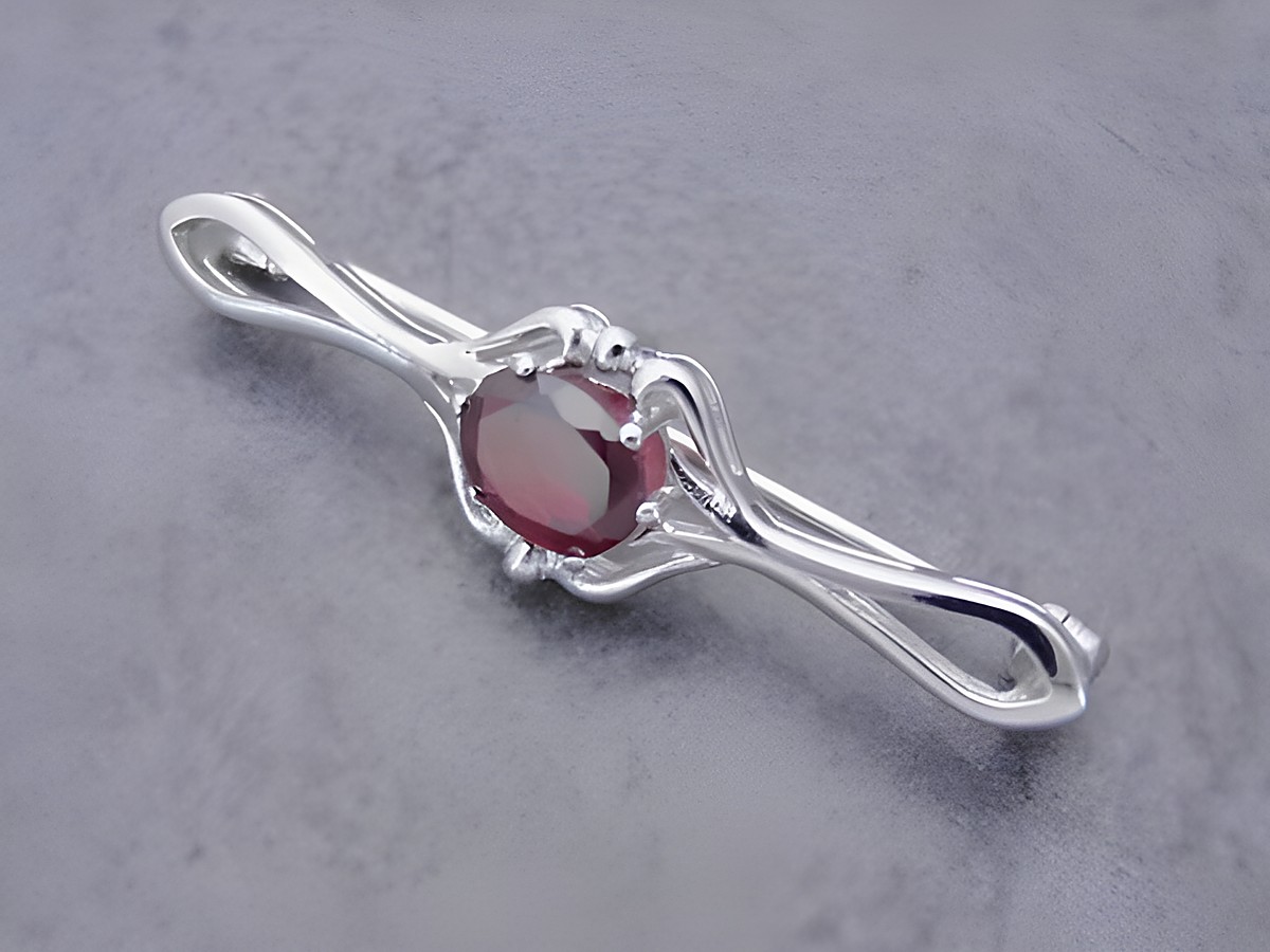 Silber Brosche vornehm mit einem ovalen Granat, Hersteller Juwelier Harnisch, elegante Gestaltung ideal für besondere Anlässe, zeitloses Schmuckstück für stilvolle Auftritte.
