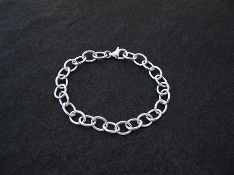 Charm Armband aus Sterling Silber im Rundanker Design, hergestellt von Juwelier Harnisch, ohne Stein, elegant und zeitlos, auf schwarzem Hintergrund präsentiert.