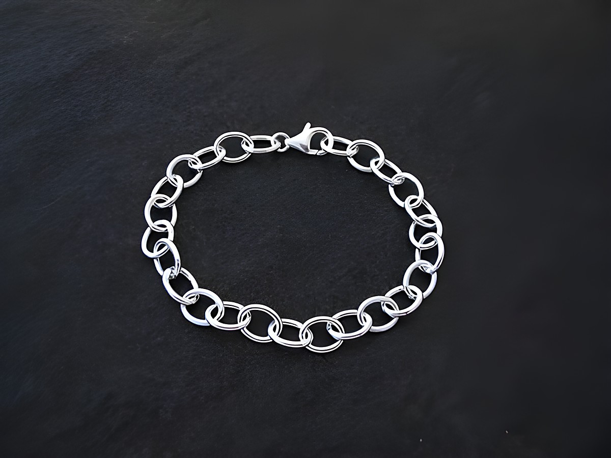 Charm Armband aus Sterling Silber im Rundanker Design, hergestellt von Juwelier Harnisch, ohne Stein, elegant und zeitlos, auf schwarzem Hintergrund präsentiert.