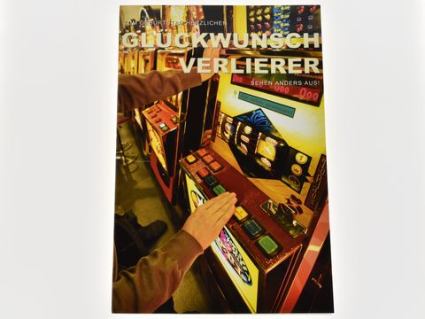 Geburtstagskarte mit dem Aufdruck Glückwunsch Verlierer, abgebildet vor Spielautomaten des Herstellers Juwelier Harnisch, illustriert mit bunten Tasten und einem modernen Design.