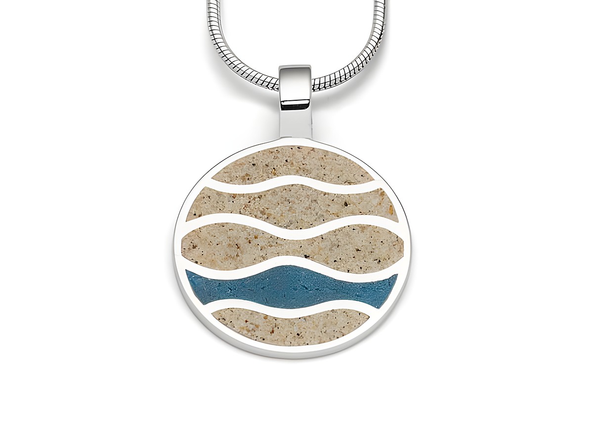 Sterling Silber Anhänger mit kreisförmigem Design, das Strandwellen darstellt. Die Wellen sind aus Strandsand und blauen Steinsand in verschiedenen Schattierungen gefertigt.