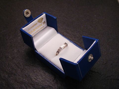 Geschenkschachtel DELUX für einen Ring in Blau, geöffnet mit einer weißen Innenauskleidung, zeigt einen Ring mit besonderem Design, Hersteller Juwelier Harnisch.
