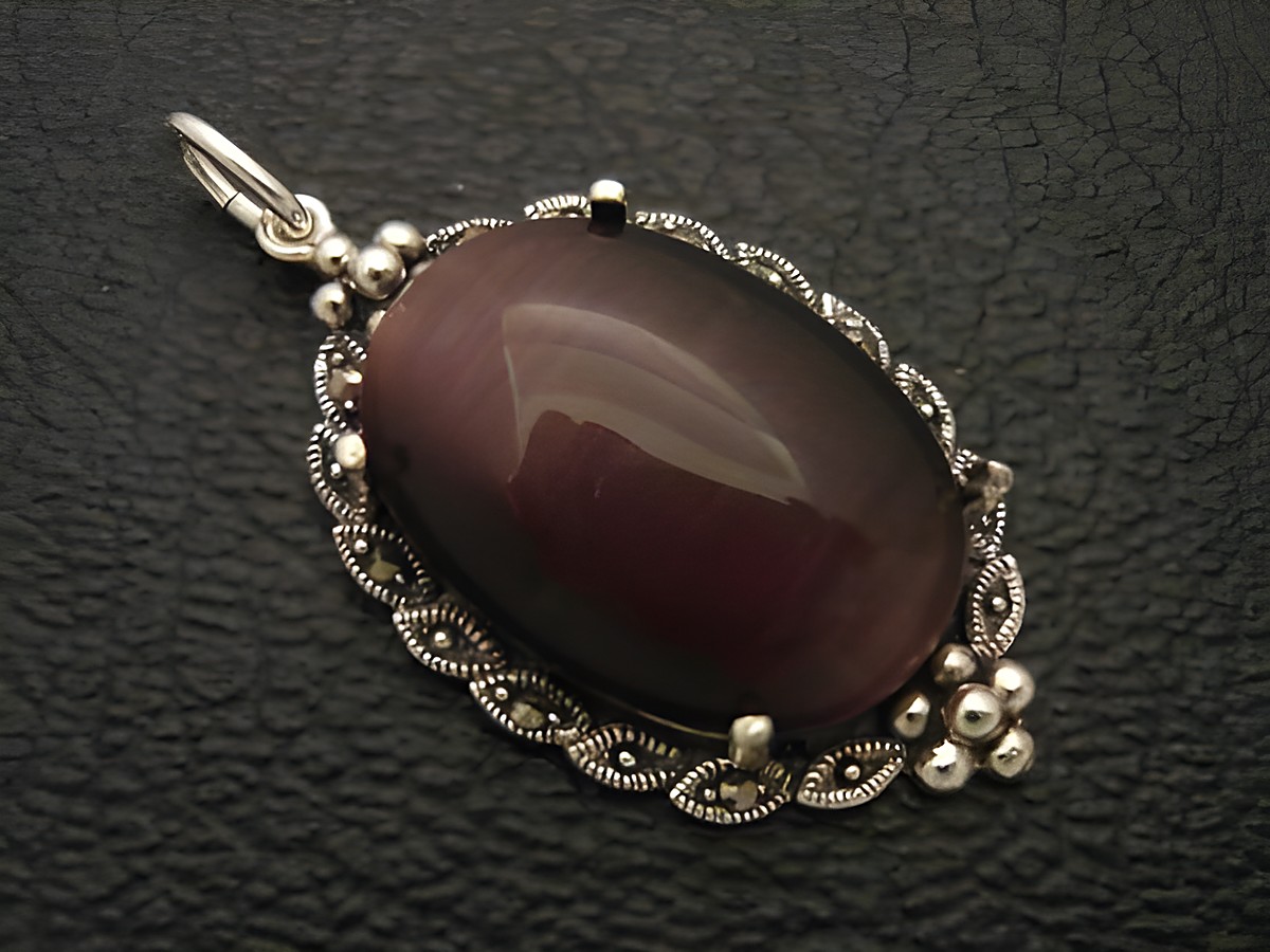 Cabochon Katzenauge lila Silber Medaillon Anhänger von Juwelier Harnisch, elegantes Design mit feiner Umrandung und glänzendem Cabochonstein, ideal für Schmuckliebhaber.