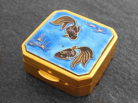 Multifunktionale Dose mit Fischen, Hersteller Juwelier Harnisch, ohne Stein. Die Dose hat eine goldene Umrahmung und einen blauen Deckel mit feinen Fischen und Wasserpflanzen.