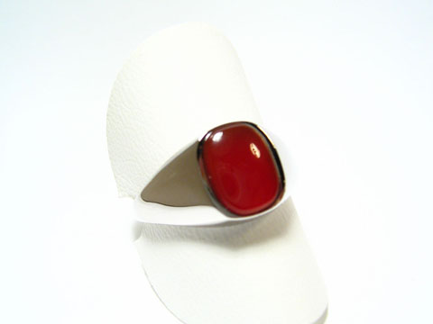 Silber Ring rhodiniert mit einem rot braunen Karneol im 70er Look, hergestellt von Juwelier Harnisch, der Ring ist verstellbar und präsentiert sich elegant auf einem weißen Ringhalter.