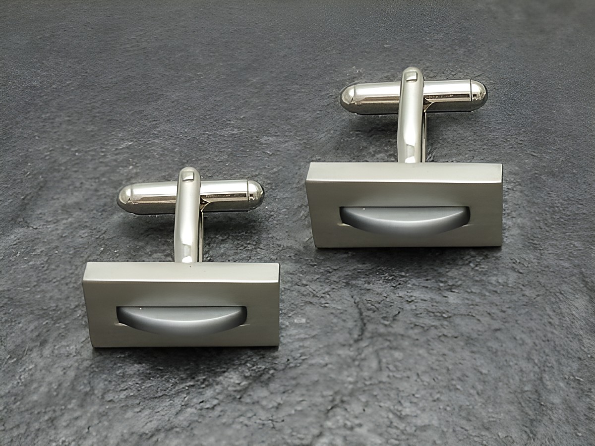 Manschettenknöpfe silberfarben mit grauer Einlage, Hersteller Juwelier Harnisch, elegantes Design für stilvolle Outfits. Ideal für besondere Anlässe und formelle Kleidung.