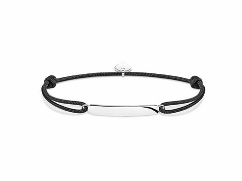 Ein elegantes Thomas Sabo Little Secrets Armband aus schwarzem Band mit einer schlichten, glänzenden Edelstahlplatte in der Mitte, ideal für persönliche Gravuren und vielseitige Tragemöglichkeiten.
