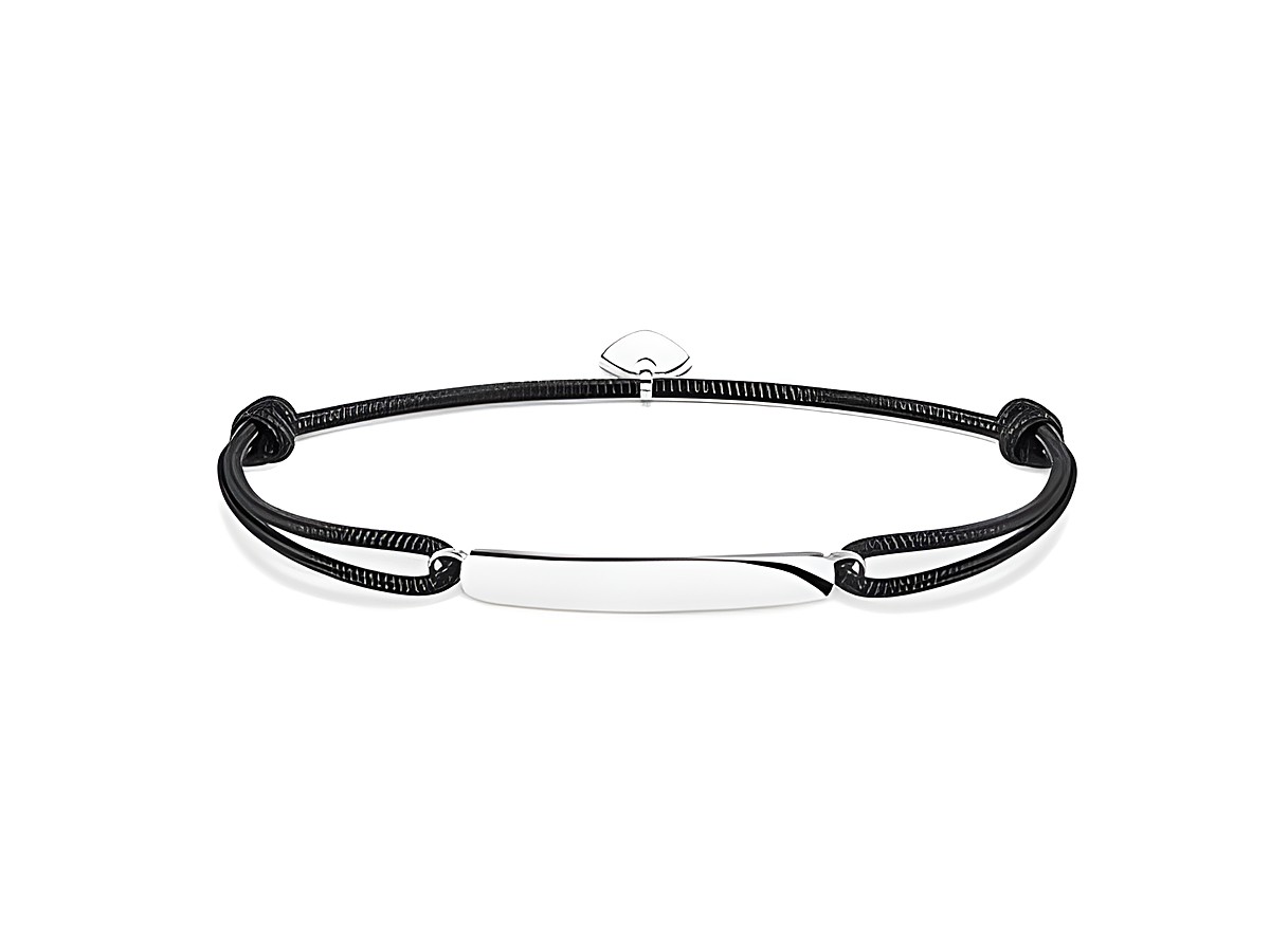 Ein elegantes Thomas Sabo Little Secrets Armband aus schwarzem Band mit einer schlichten, glänzenden Edelstahlplatte in der Mitte, ideal für persönliche Gravuren und vielseitige Tragemöglichkeiten.