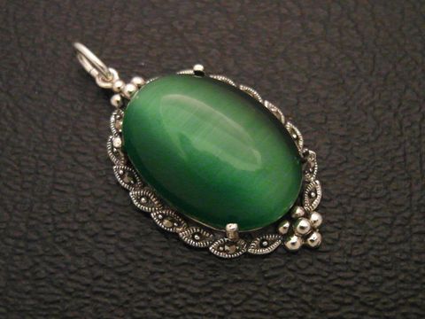 Cabochon Katzenauge grün in Silber Medaillon Anhänger, Hersteller Juwelier Harnisch, elegantes Design mit filigranen Details und glänzender Oberfläche des Cabochonsteins.