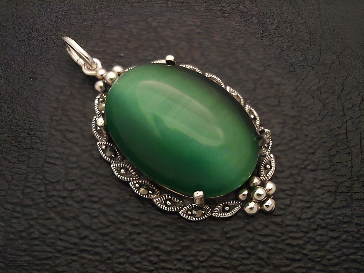 Cabochon Katzenauge grün in Silber Medaillon Anhänger, Hersteller Juwelier Harnisch, elegantes Design mit filigranen Details und glänzender Oberfläche des Cabochonsteins.