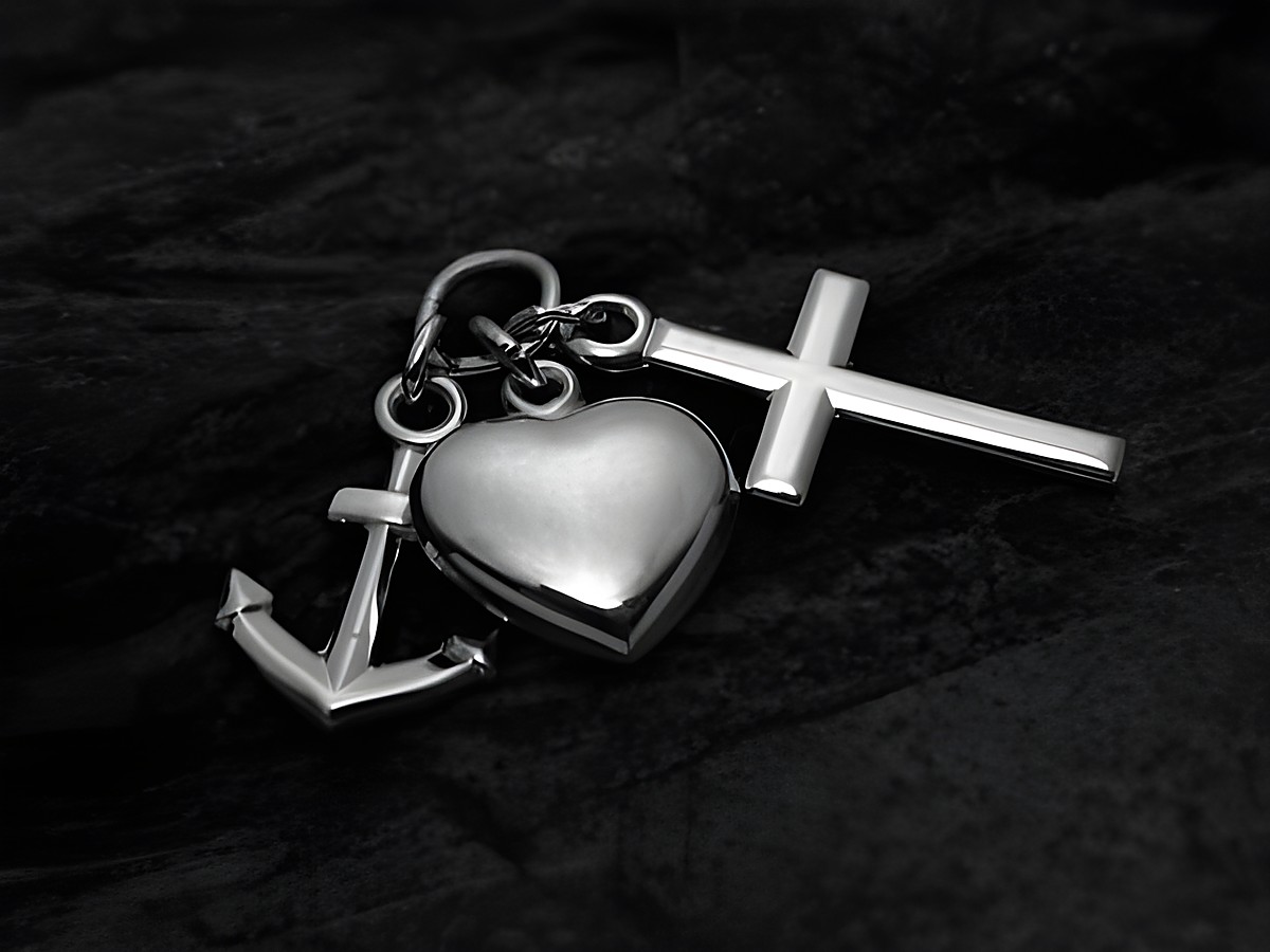 Ein Anhänger aus rhodiniertem Sterling Silber mit den Symbolen Glaube, Liebe und Hoffnung, dargestellt durch ein Kreuz, ein Herz und einen Anker, ideal für eine stilvolle Schmuckkollektion.