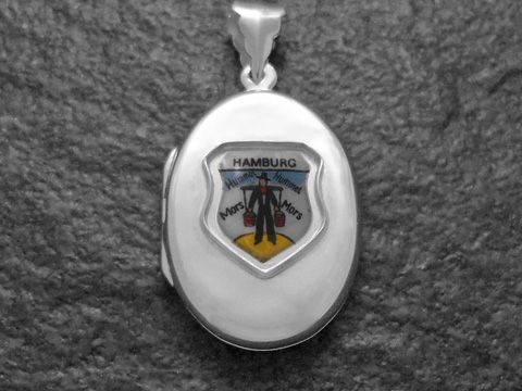 Silberne Medaille mit dem Wappen von Hamburg, gestaltet von Juwelier Harnisch, zeigt einen Mann in traditioneller Kleidung und den Schriftzug Hamburg. Ideal als Schmuckstück für Liebhaber der Stadt.