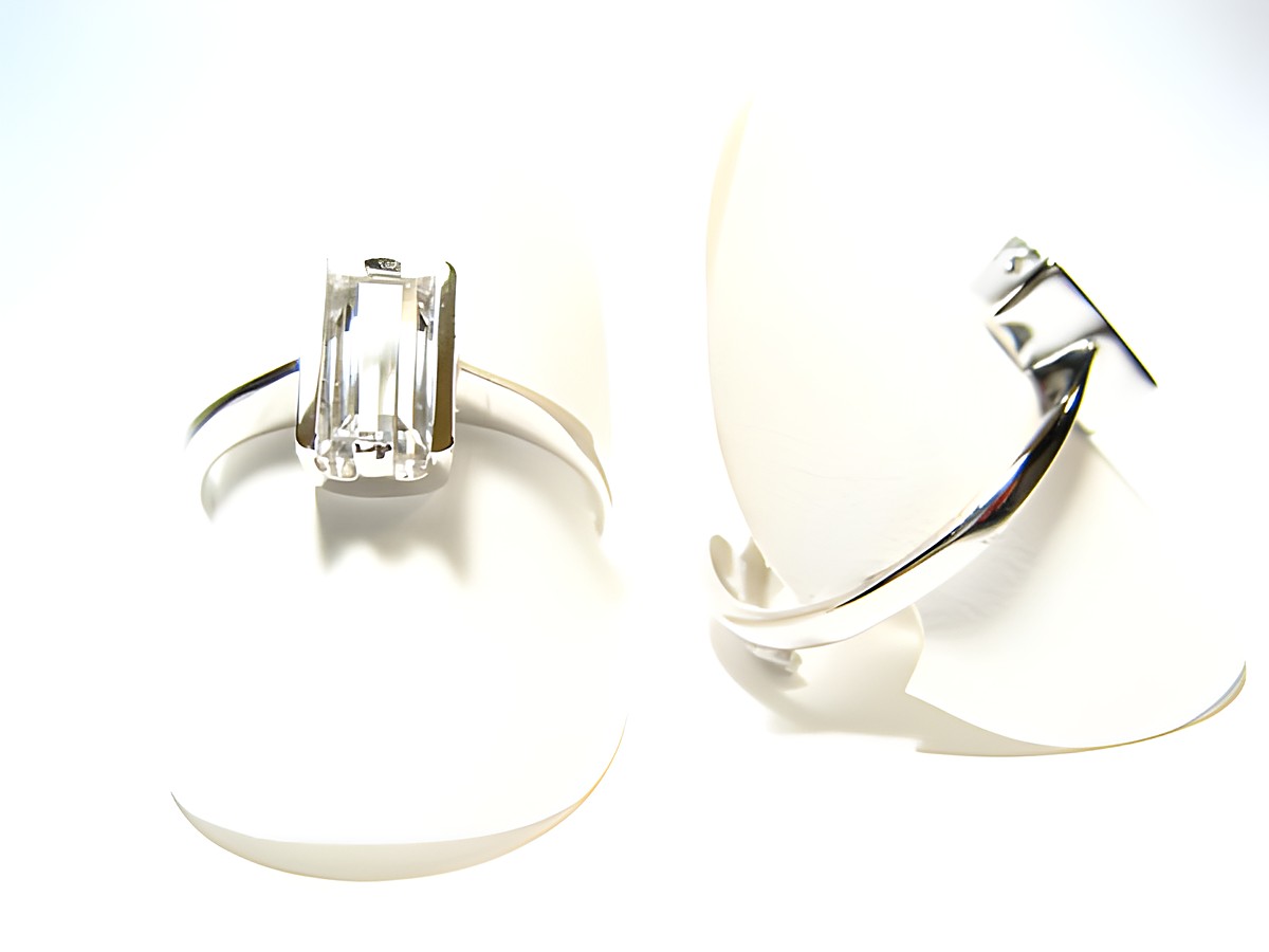 Silber Ring rhodiniert mit einem in weiß gefassten Stein, verstellbar, Hersteller Juwelier Harnisch. Der Ring präsentiert sich elegant auf einem weißen Untergrund.