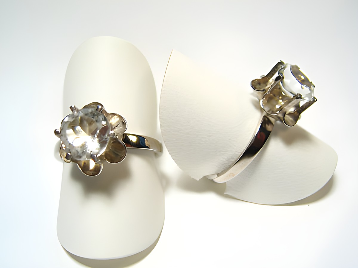 Silber Ring rhodiniert mit echt Bergkristall gefasst, Hersteller Juwelier Harnisch, verstellbare Ringe auf weißen Ringhaltern präsentiert.