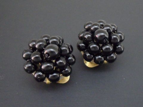 Ohrclip aus goldfarbenem Metall mit schwarzem Perlentraum, hergestellt von Juwelier Harnisch, stilvolles Design mit synthetischen Zuchtperlen.