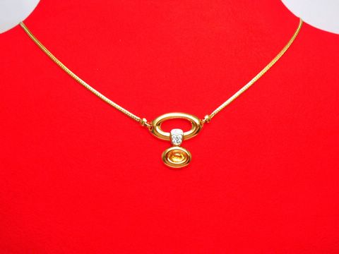 Collier Goldkette 750 mit Mittelteil aus Citrin und Zirkonia, Länge 43cm, Hersteller Juwelier Harnisch, präsentiert auf rotem Hintergrund.