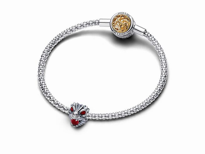 Das Bild zeigt ein Silberarmband mit einem Drachen Charm aus der Game of Thrones Kollektion von Pandora. Der Charm ist handgefertigt und mit roten Kristallen verziert.