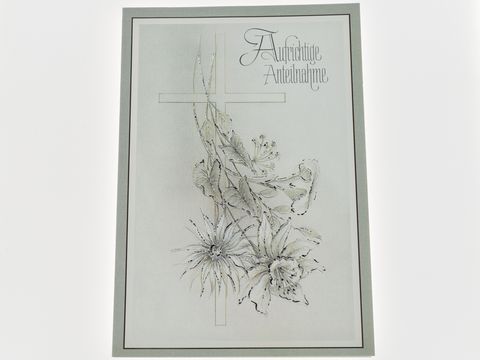 Trauerkarte mit einem Kreuz und stilisierten Blumenmotiven. Elegant gestaltet in sanften Farben, ideal für Kondolenz und Trauerbekundungen. Hersteller: Juwelier Harnisch.