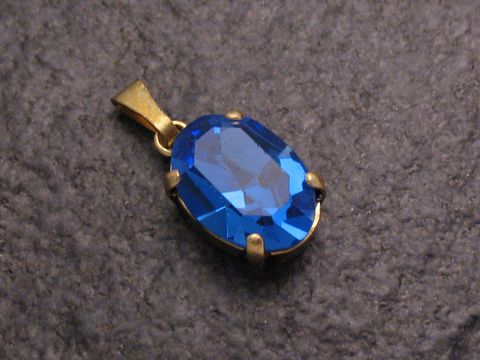 Blauer Strass Anhänger im ovalen Design, ideal für einen sexy City Look, hergestellt von Juwelier Harnisch, funkelt mit intensiver blauer Farbe.