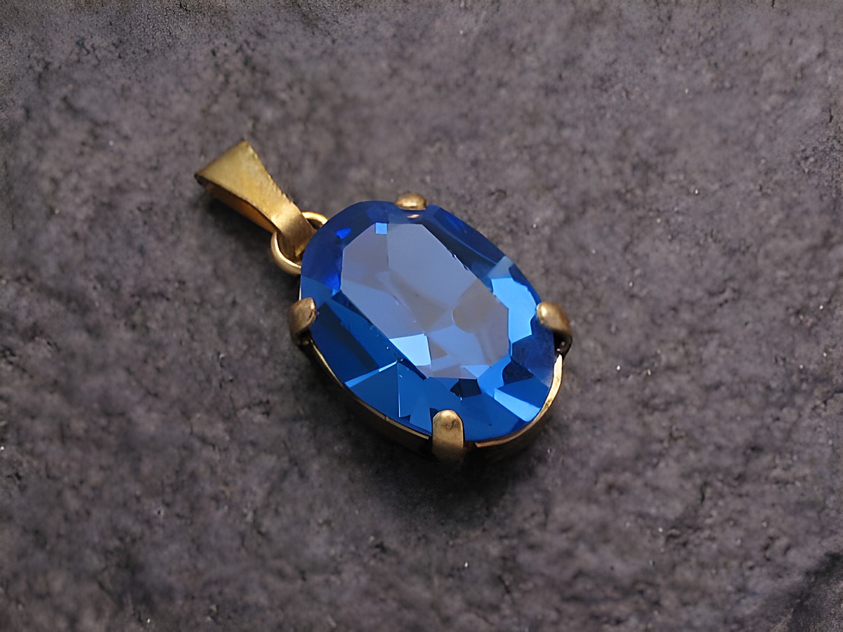 Blauer Strass Anhänger im ovalen Design, ideal für einen sexy City Look, hergestellt von Juwelier Harnisch, funkelt mit intensiver blauer Farbe.