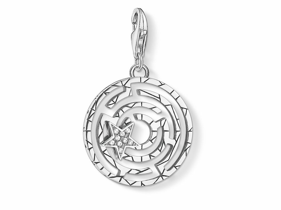Ein filigraner Thomas Sabo Charm-Anhänger aus Sterlingsilber im Design eines Lebenslabyrinths, geschmückt mit funkelndem weißen Zirkonia in Form von Sonne, Mond und Sternen.