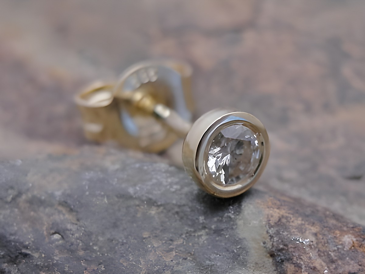 Rund 1 Ohrstecker unisex aus Gold 585 ansprechend mit Brillant, Hersteller Juwelier Harnisch, Einzelohrringe 1 Stück auf einem natürlichen Untergrund abgebildet.