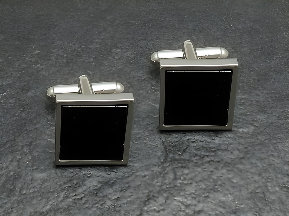 Silberfarbene Manschettenknöpfe im Onyx-Look von Juwelier Harnisch, quadratische Form, elegant und zeitlos, ideal für festliche Anlässe und als stilvolles Accessoire.