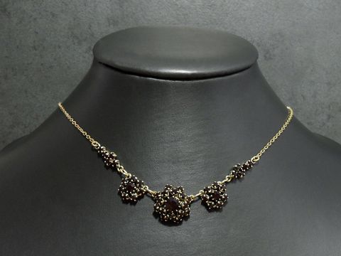 Strasskette in granatrot, feminin, Länge 42-46 cm, goldfarben, gefertigt von Juwelier Harnisch, mit goldfarbener Fassung und dekorativen Elementen.