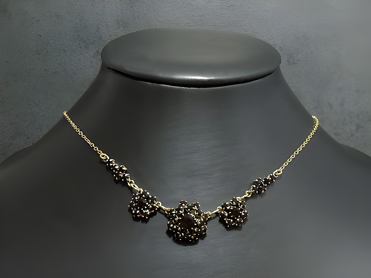 Strasskette in granatrot, feminin, Länge 42-46 cm, goldfarben, gefertigt von Juwelier Harnisch, mit goldfarbener Fassung und dekorativen Elementen.