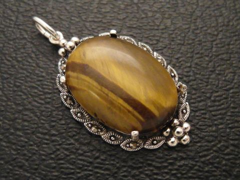 Cabochon Tigerauge in ovaler Form, eingefasst in ein filigranes Silber Medaillon, Hersteller Juwelier Harnisch, schimmernde Oberflächenstruktur und elegante Gestaltung.