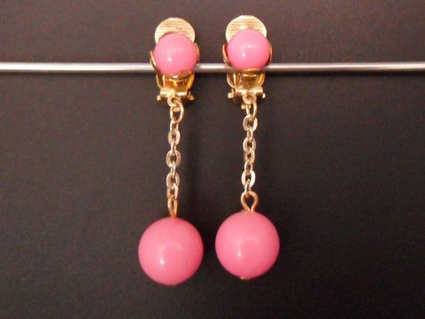 Rosa zeitlose Ohrclips aus goldfarbenem Kunstharz mit einer eleganten Kette, Hersteller Juwelier Harnisch, ideal für stilvolle Akzente und besondere Anlässe.