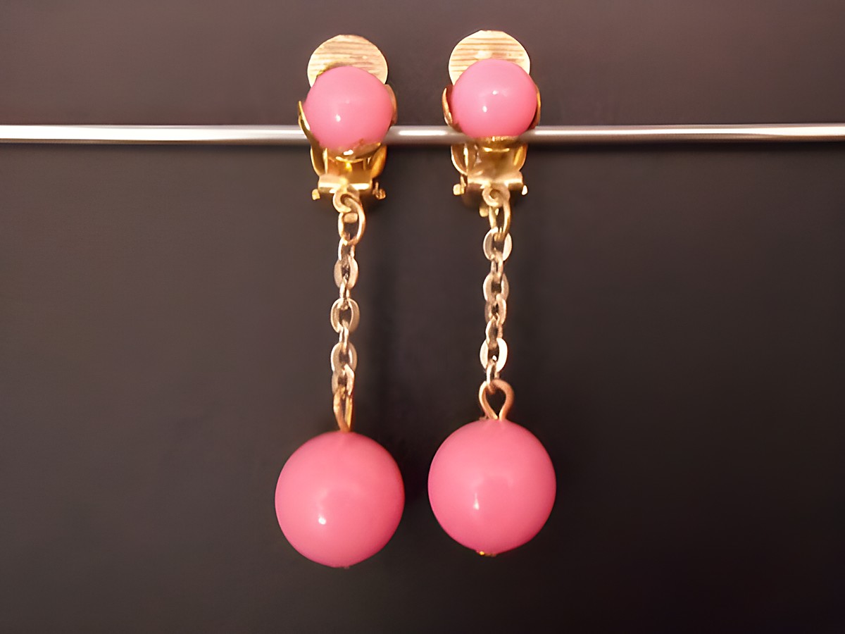 Rosa zeitlose Ohrclips aus goldfarbenem Kunstharz mit einer eleganten Kette, Hersteller Juwelier Harnisch, ideal für stilvolle Akzente und besondere Anlässe.