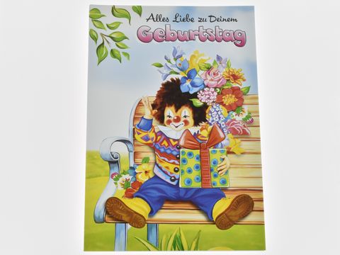 Geburtstagskarte mit fröhlichem Clown, der auf einer Bank sitzt und ein buntes Geschenk sowie einen Strauß Blumen hält, Hersteller: Juwelier Harnisch, Geburtstagskarten.
