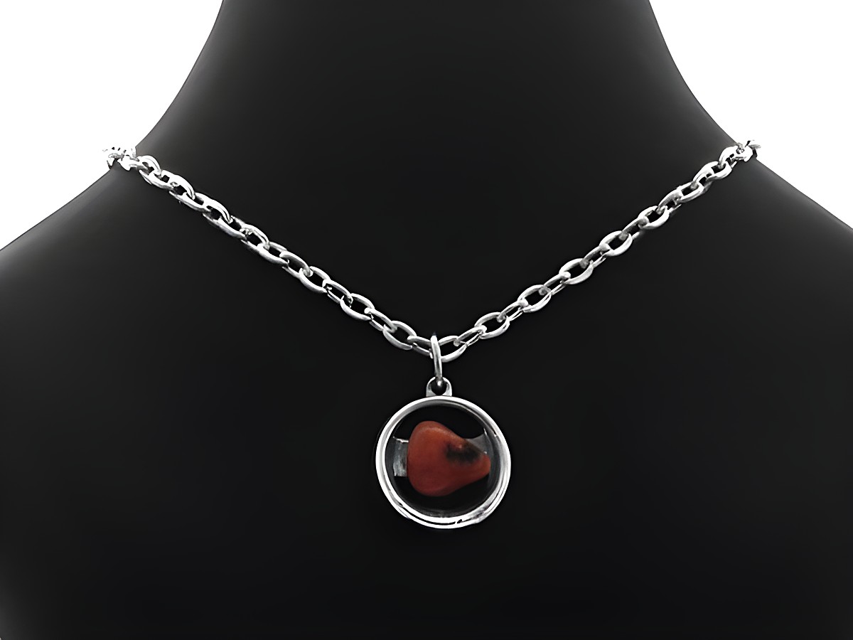 Kette mit Anhänger aus versilbertem Material, 40 cm lang, verziert mit einem Rhodochrosit, präsentiert auf einem schwarzen Halsband. Hersteller ist Juwelier Harnisch, Set Kette und Anhänger.