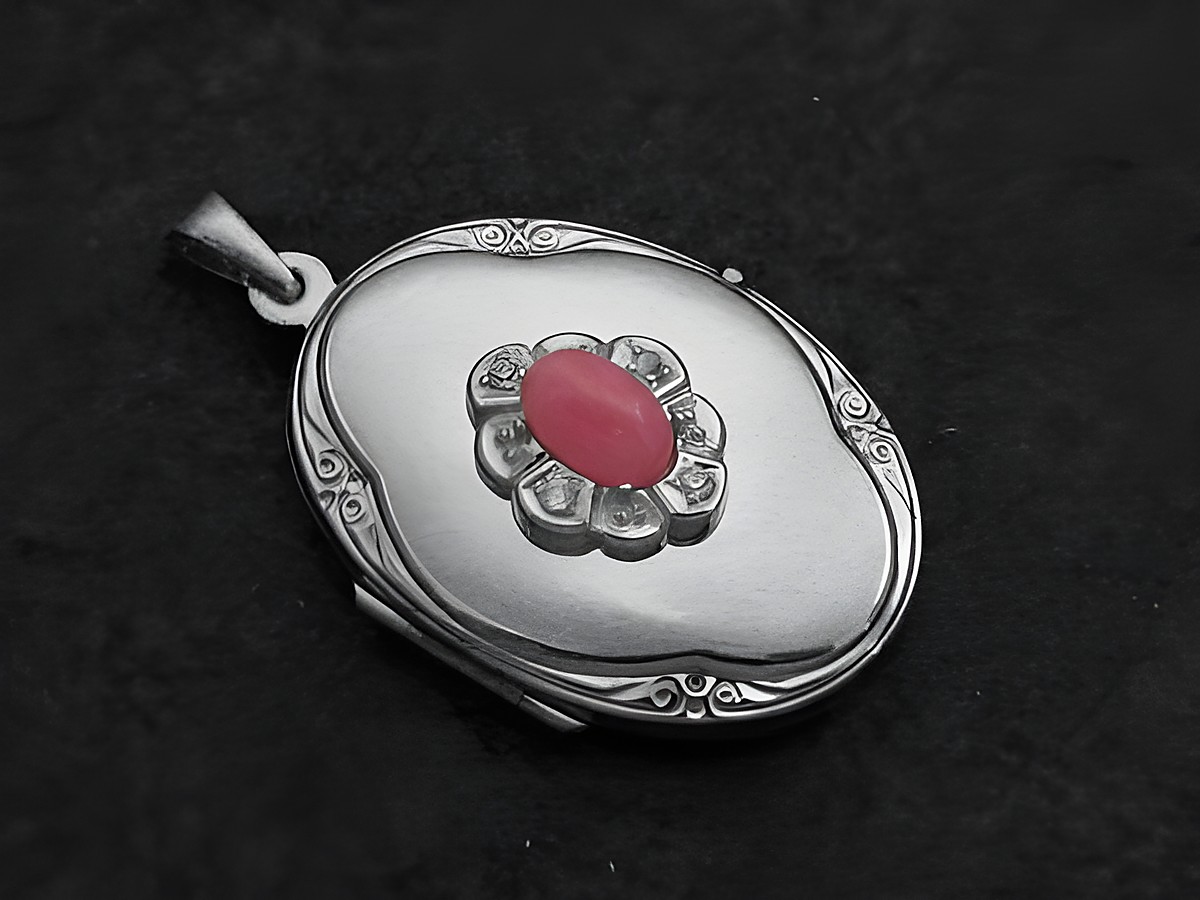 Rhodochrosit rosa Medaillon Cabochon in Weißgold 585, gefertigt von Juwelier Harnisch. Das Medaillon zeigt eine ovale Form mit einem zentralen Cabochon und dezenter Verzierung.