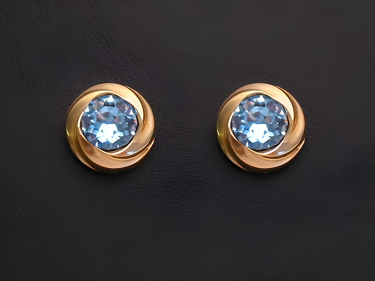 Hellblaue facettierte Ohrringe aus Gold mit spiralförmigem Design, Hersteller Juwelier Harnisch, ergänzt durch weitere Steine. Ideal für elegante Anlässe.