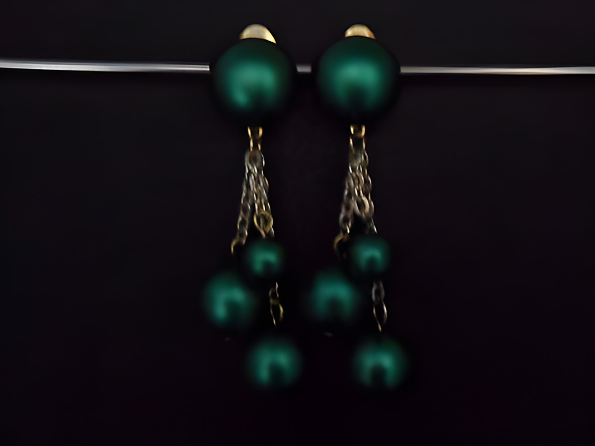 Ohrclip in meeresgrün mit zeitlosem Design, verziert mit goldfarbenen Elementen und Kunstharz. Hersteller: Juwelier Harnisch. Elegantes Accessoire mit Hingucker-Potential.
