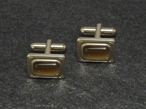 Beige Manschettenknöpfe im Design von Juwelier Harnisch, goldfarben, Größe 17 mm, rechteckige Form mit einer eleganten Struktur und einem dezenten Farbspiel.