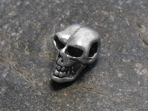 Totenkopf - 925 Sterling Silber Anhänger - klein - Hersteller: Juwelier Harnisch, detailreiche Darstellung eines kleinen Totenkopfes aus Silber auf grauem Hintergrund.