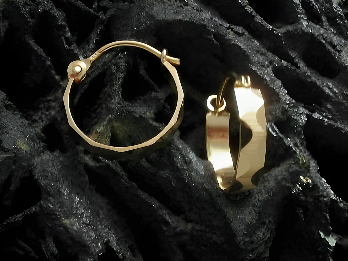 Creolen 1,4 cm aus Gold 333, gemustert und teilmattiert, hergestellt von Juwelier Harnisch, Durchmesser bis 15 mm, präsentieren sich elegant auf einem dunklen Hintergrund.